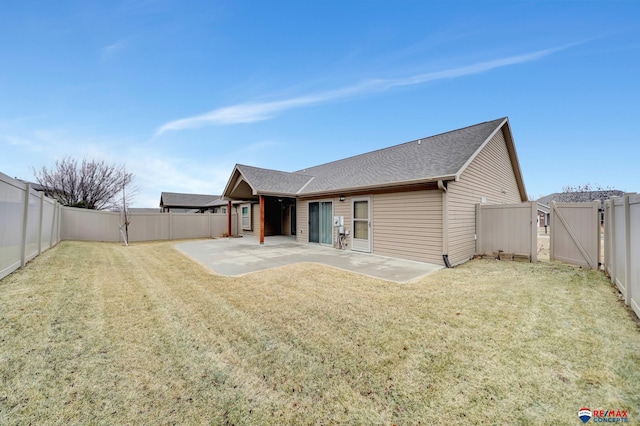 rear view of house featuring a yard and a patio