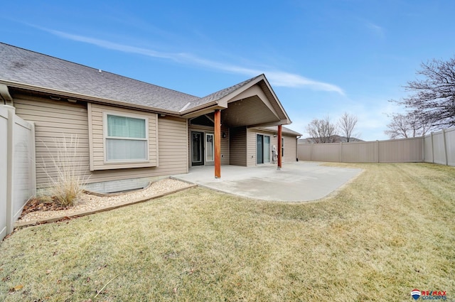 rear view of house with a yard and a patio