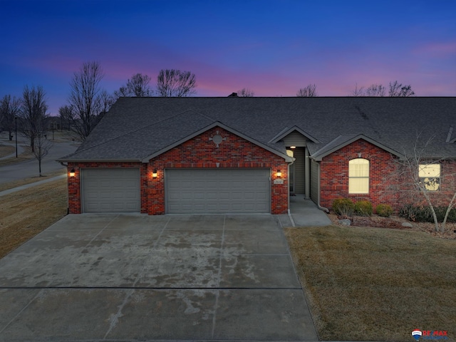 ranch-style home with a garage and a lawn