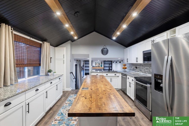 kitchen featuring stainless steel appliances, hardwood / wood-style floors, white cabinets, and butcher block countertops