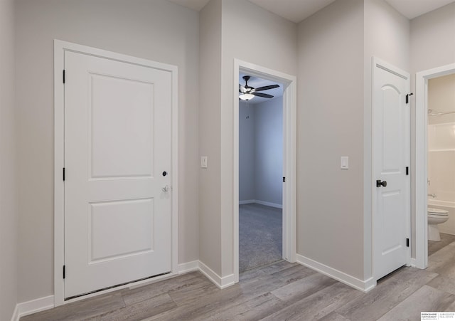 hallway with light hardwood / wood-style floors