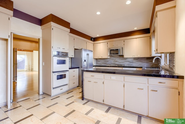 kitchen featuring white cabinetry, sink, tasteful backsplash, and stainless steel appliances