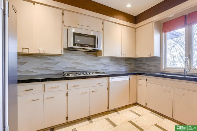 kitchen with white cabinetry, sink, tasteful backsplash, and appliances with stainless steel finishes