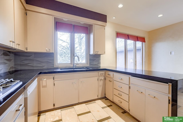 kitchen featuring tasteful backsplash, dishwasher, sink, and white cabinets