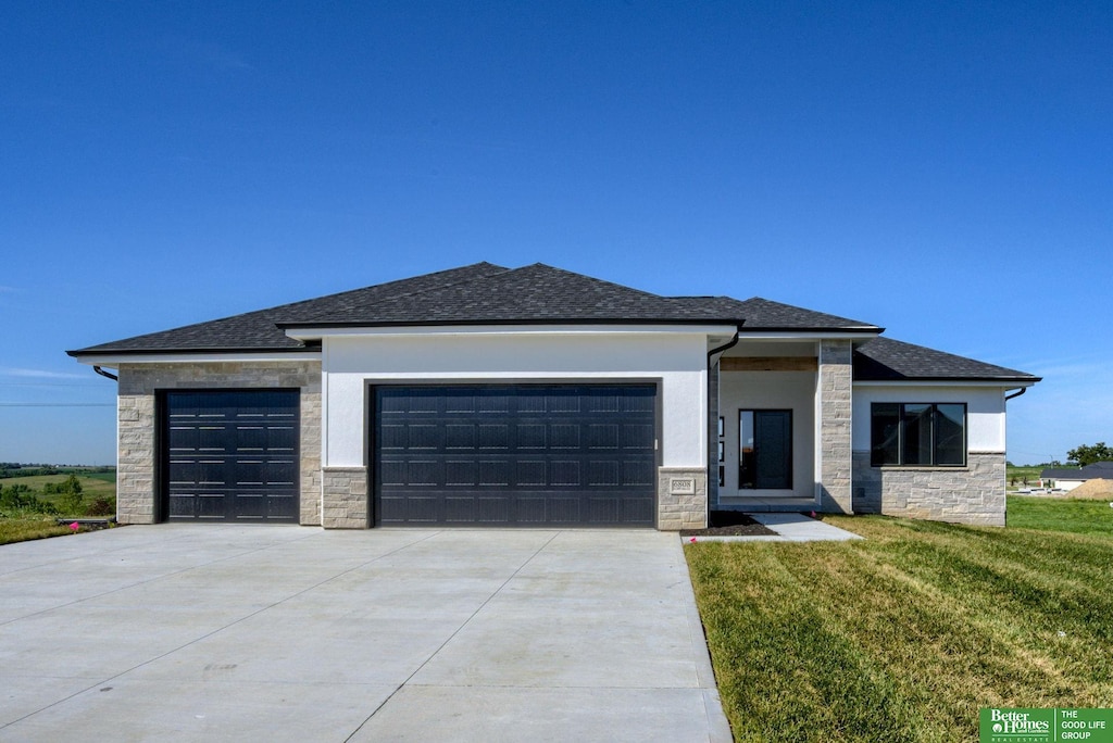 prairie-style home with a garage and a front yard