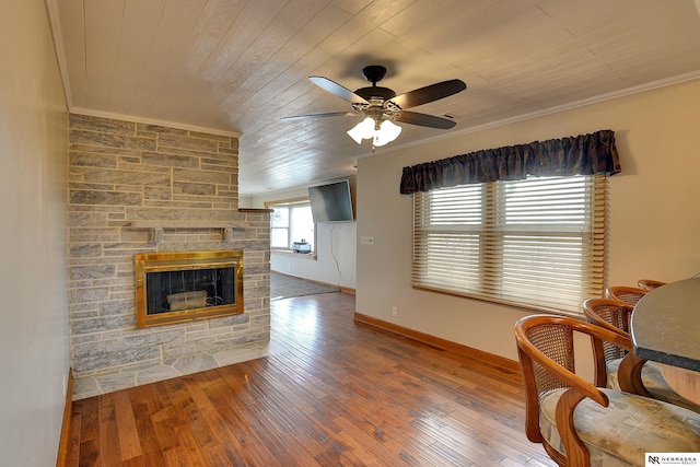 sitting room with crown molding, wood-type flooring, and a stone fireplace