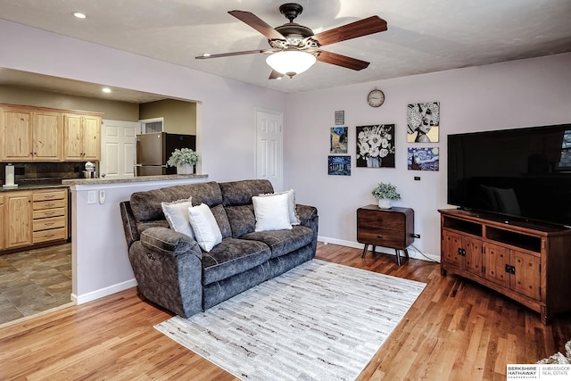 living room featuring light hardwood / wood-style flooring and ceiling fan