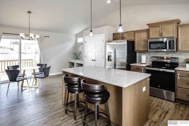 kitchen featuring dark wood-type flooring, stainless steel appliances, a center island, and decorative backsplash