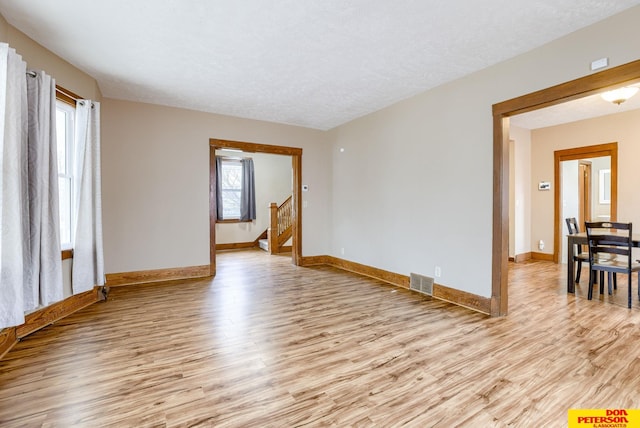 spare room featuring light hardwood / wood-style flooring and a textured ceiling