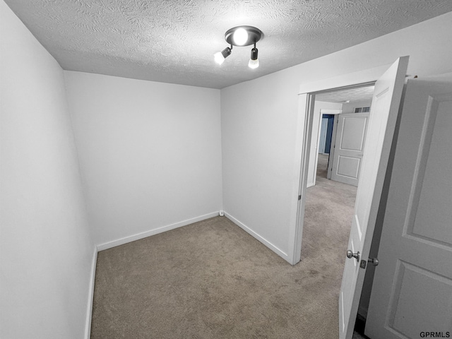 carpeted empty room with a textured ceiling