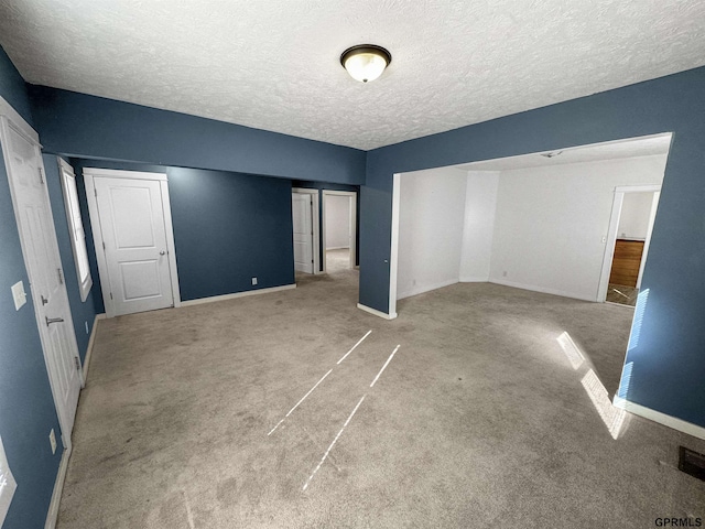 unfurnished bedroom with light colored carpet and a textured ceiling