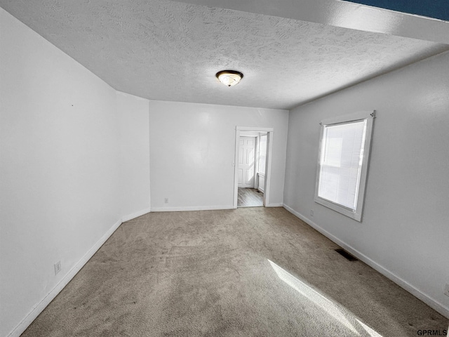 carpeted spare room with a textured ceiling