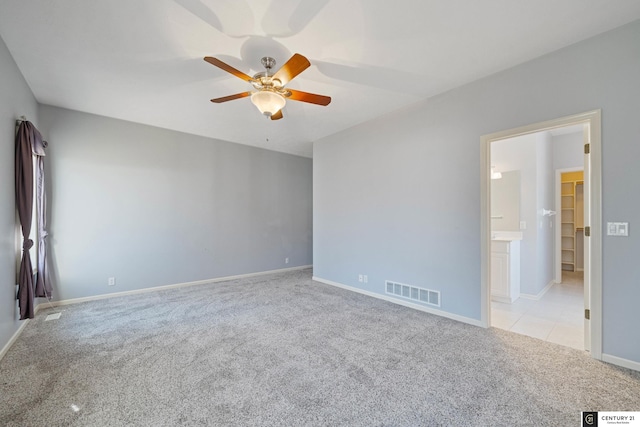 carpeted spare room featuring ceiling fan