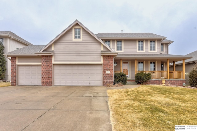 view of front facade featuring a garage, a front yard, and covered porch