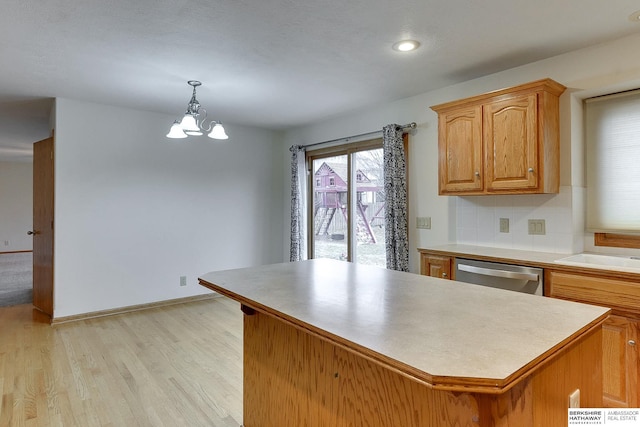 kitchen featuring a center island, light hardwood / wood-style flooring, stainless steel dishwasher, pendant lighting, and decorative backsplash