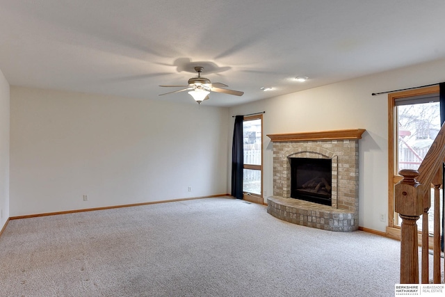 unfurnished living room featuring ceiling fan, light colored carpet, and a brick fireplace