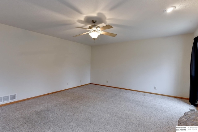 carpeted spare room featuring ceiling fan