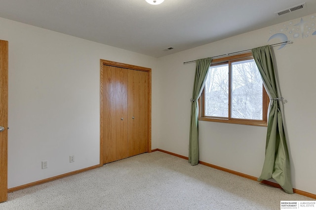 unfurnished bedroom with light carpet and a closet