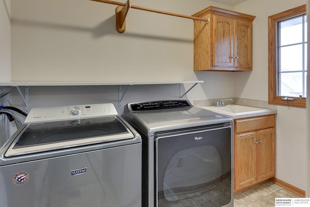 laundry room with washer and dryer, sink, cabinets, and a healthy amount of sunlight