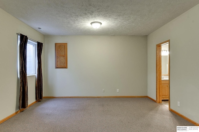 carpeted spare room with a textured ceiling