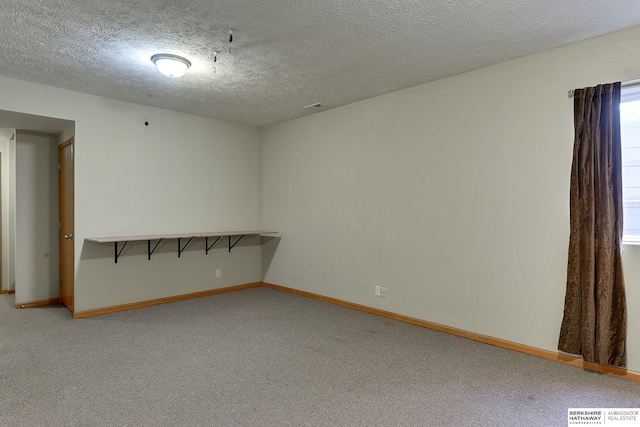 carpeted spare room with a textured ceiling