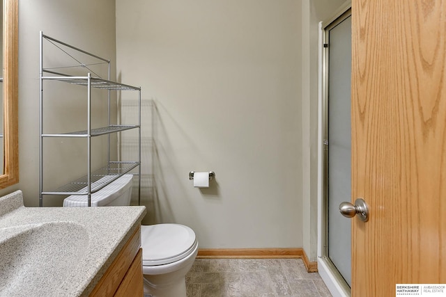 bathroom with vanity, toilet, and a shower with shower door