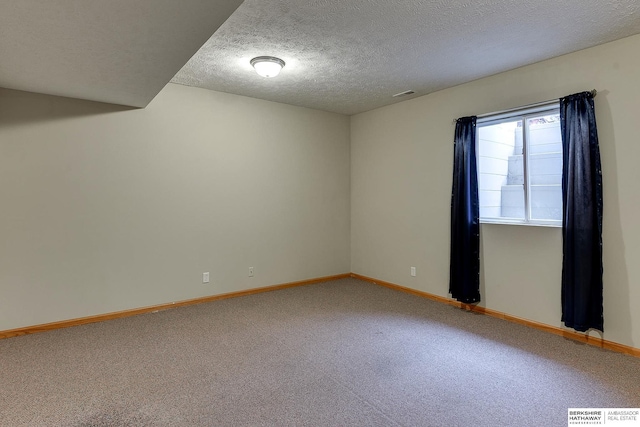 carpeted spare room featuring a textured ceiling