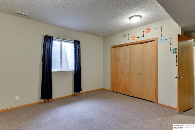 unfurnished bedroom featuring a closet, light carpet, and a textured ceiling