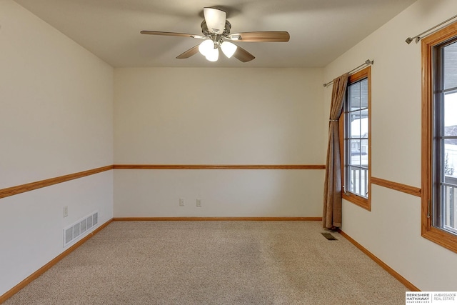 spare room with ceiling fan and carpet