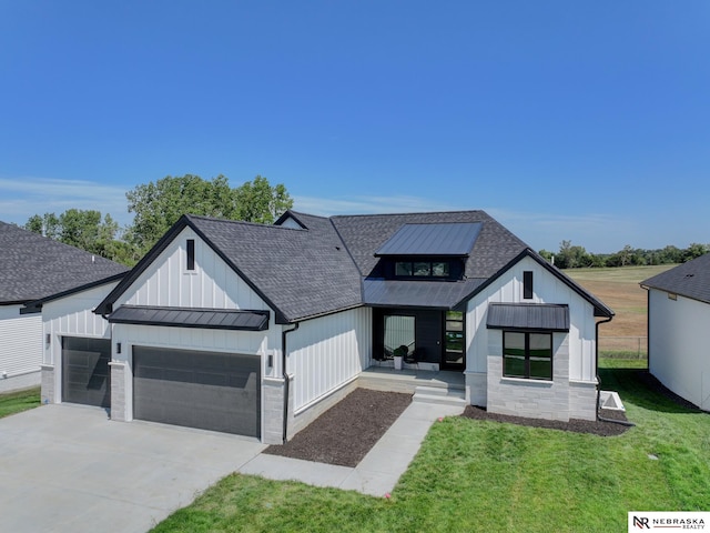 modern farmhouse style home featuring a garage and a front lawn