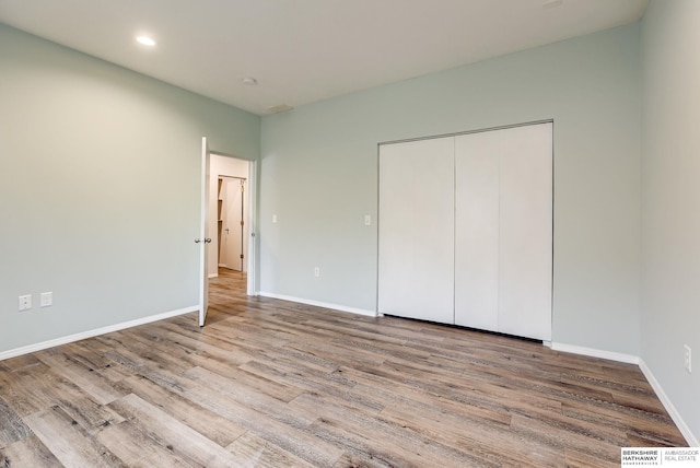 unfurnished bedroom featuring light hardwood / wood-style floors and a closet