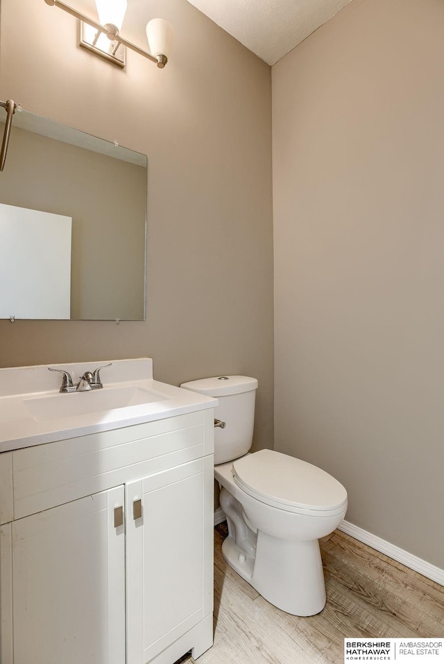 bathroom with vanity, hardwood / wood-style floors, and toilet