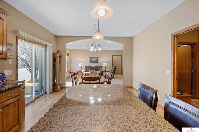 dining space with a notable chandelier and light wood-type flooring