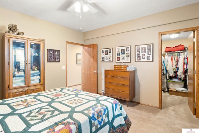 bedroom with a closet, a spacious closet, light colored carpet, ceiling fan, and french doors