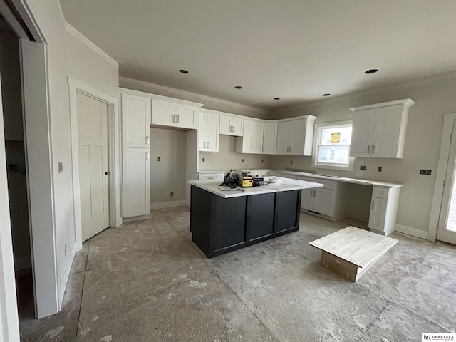 kitchen with baseboards, a center island, and white cabinetry