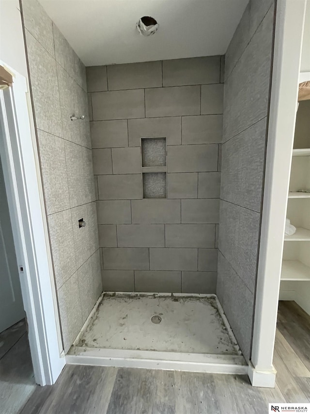 bathroom with a stall shower and wood finished floors