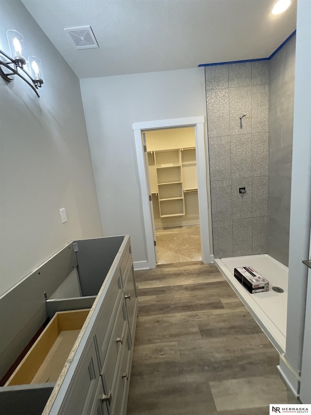 bathroom featuring visible vents, a shower stall, and wood finished floors