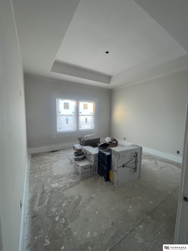 unfurnished room featuring baseboards and a tray ceiling