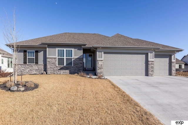 prairie-style house featuring a garage and a front yard