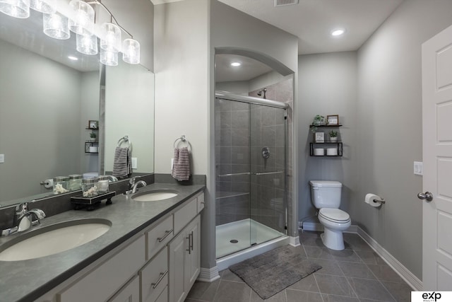 bathroom with tile patterned flooring, vanity, an enclosed shower, and toilet