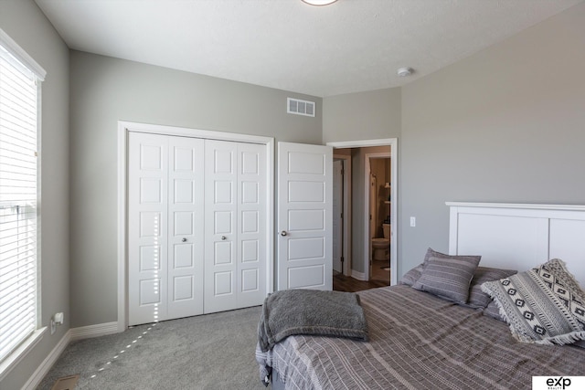 carpeted bedroom featuring multiple windows and a closet