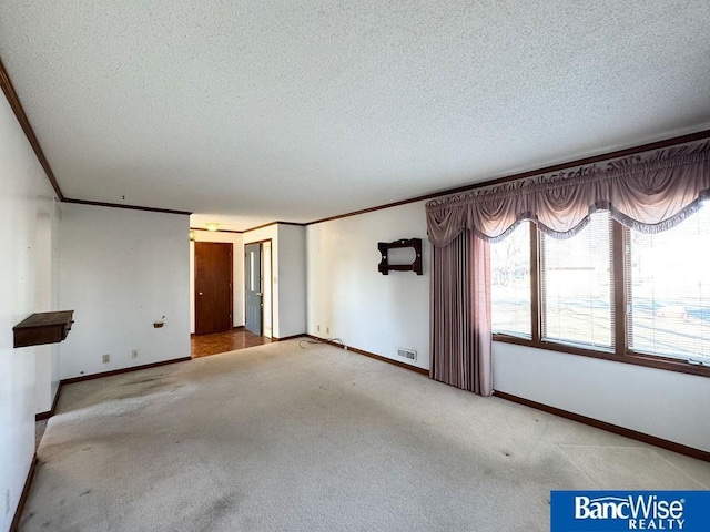 carpeted spare room featuring ornamental molding and a textured ceiling