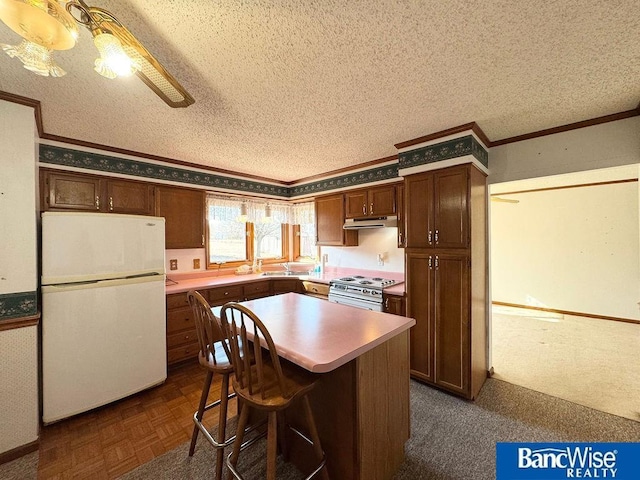 kitchen featuring a textured ceiling, range with electric stovetop, white refrigerator, ornamental molding, and a kitchen island