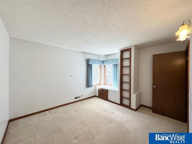 unfurnished bedroom with carpet floors and a textured ceiling