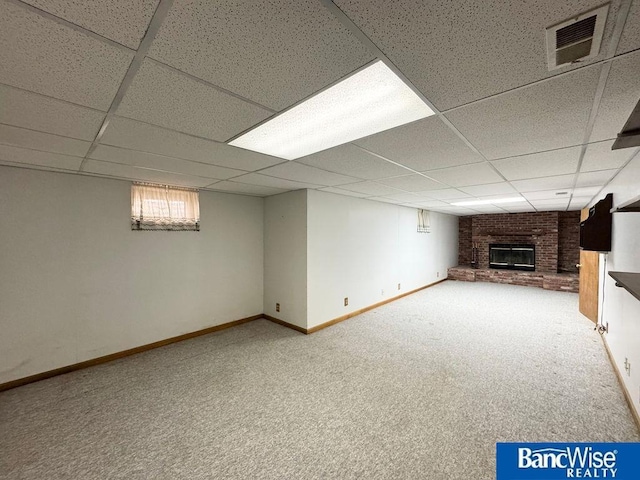 basement featuring a fireplace, carpet floors, and a paneled ceiling