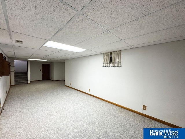 basement with light carpet and a drop ceiling