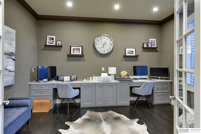 home office with built in desk, ornamental molding, and dark hardwood / wood-style floors