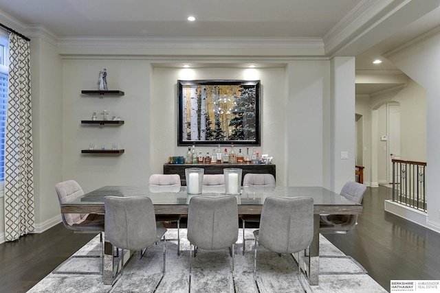 dining area with ornamental molding and dark hardwood / wood-style flooring