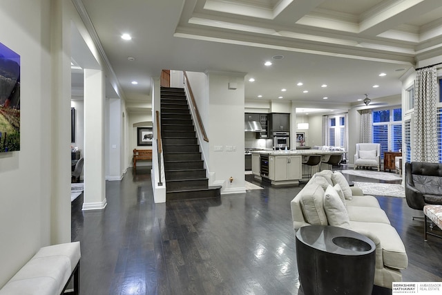 living room featuring beam ceiling, crown molding, dark wood-type flooring, and ceiling fan