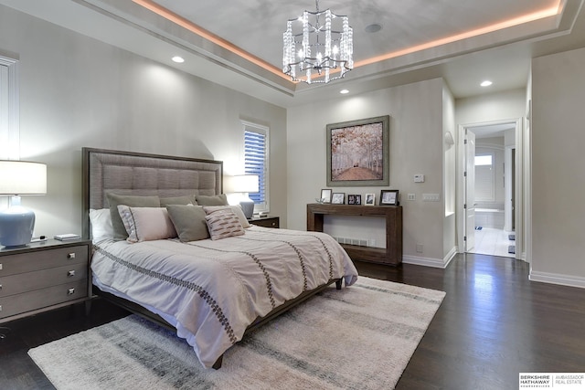 bedroom featuring a chandelier, dark hardwood / wood-style flooring, and a tray ceiling